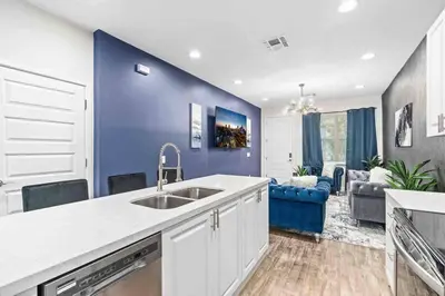a kitchen with a sink and a blue wall at SUPER POSH- SLEEPs 16 wDESIGNs & NEAR Disney in Kissimmee