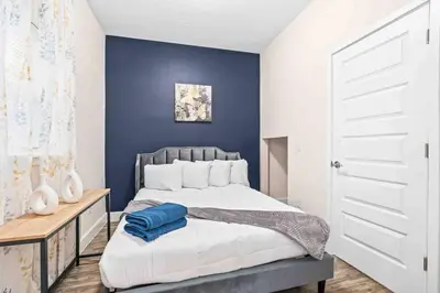 a bedroom with a bed and a blue wall at SUPER POSH- SLEEPs 16 wDESIGNs & NEAR Disney in Kissimmee