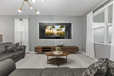 a living room with a couch and a table at SUPER BLISS - 9BDR SLEEPs 30 - MOVIE ROOM & POOL in Kissimmee