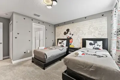 a bedroom with two beds and a mural of mickeys at SUPER BLISS - 9BDR SLEEPs 30 - MOVIE ROOM & POOL in Kissimmee