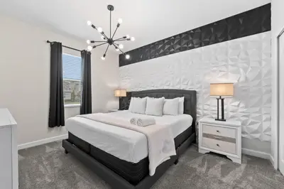 a bedroom with a large bed and a window at SUPER BLISS - 9BDR SLEEPs 30 - MOVIE ROOM & POOL in Kissimmee