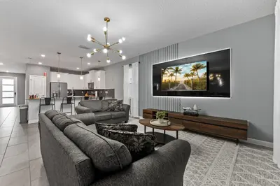 a living room with two couches and a kitchen at SUPER BLISS - 9BDR SLEEPs 30 - MOVIE ROOM & POOL in Kissimmee
