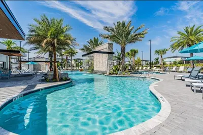 a swimming pool at a resort with palm trees at SUPER CIELO - 12BDR 11BAs - FUN THEME w POOL in Orlando