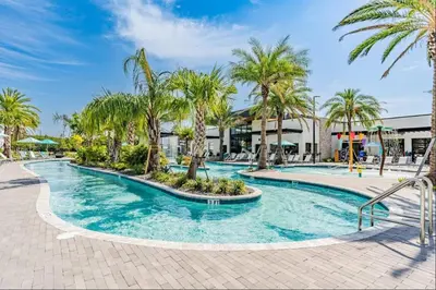 a swimming pool with palm trees in a resort at SUPER CIELO - 12BDR 11BAs - FUN THEME w POOL in Orlando