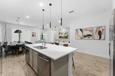 a kitchen with a sink and a dining room at SUPER CIELO - 12BDR 11BAs - FUN THEME w POOL in Orlando