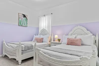 two white beds in a bedroom with purple walls at SUPER GIANT - 12BD 12BAs - SLEEP 38 & NEAR DiSNEY in Kissimmee