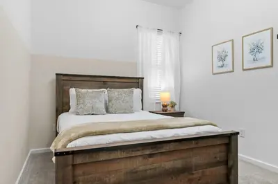 a bedroom with a large bed with a wooden headboard at SUPER GIANT - 12BD 12BAs - SLEEP 38 & NEAR DiSNEY in Kissimmee