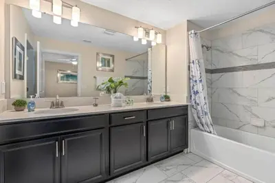 a bathroom with two sinks and a tub and a mirror at Super Chill - 5 Bedrooms WPOOls in Kissimmee