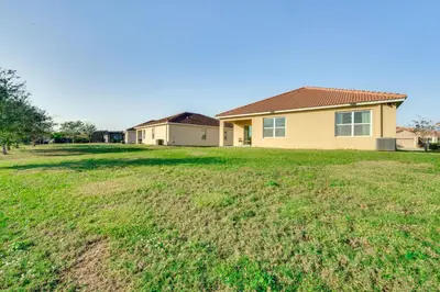 a house with a large grassy yard at 7 Mi to USTA Waterfront Tennis House with Yard! in Kissimmee