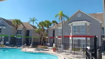a villa with a swimming pool and palm trees at Two bed condo in Parkway Palms Resort condo in Orlando