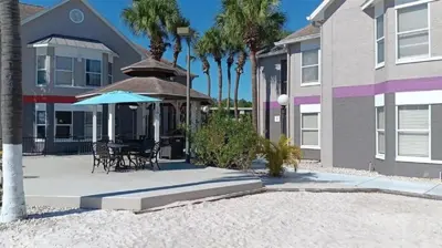 a house with a patio with a table and an umbrella at Two bed condo in Parkway Palms Resort condo in Orlando