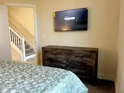a bedroom with a bed and a flat screen tv on the wall at Serenity Townhome Getaway 4 bed 3 bath home near Disney in Clermont FL in Orlando