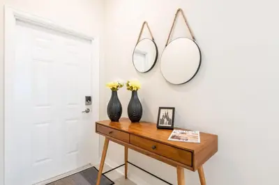 two vases on a table with two mirrors on the wall at Apartamento Moderno 2Q | Quarto Temático do Mickey in Kissimmee