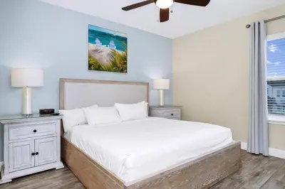 a bedroom with a white bed and a ceiling fan at Comfy Villa Near Disney With Margaritaville Resort & Island H20 Access - 8155Cp in Orlando