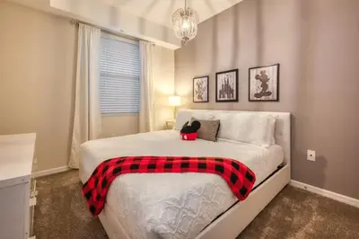 a bedroom with a bed with a red and black blanket at Apartamento Moderno 2Q | Quarto Temático do Mickey in Kissimmee