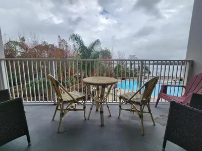 a balcony with a table and chairs and a pool at Orlando 1st Floor - 5 min Disney in Orlando
