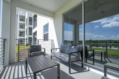 a balcony with two chairs and a table on it at Apto 2Q Vista Lago | 10 min Disney in Kissimmee