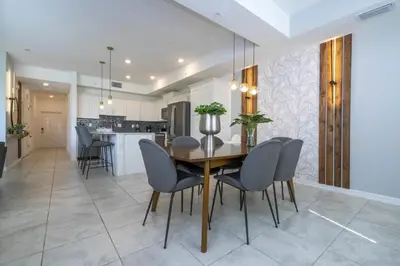 a kitchen and dining room with a wooden table and chairs at Apto 2Q Vista Lago | 10 min Disney in Kissimmee