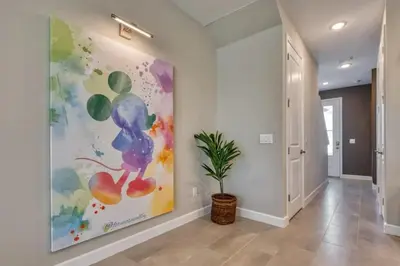 a hallway with a painting on the wall and a potted plant at 7984-Formosa Valley Resort – Vila Luxuosa Perto da Disney (Piscina Aquecida & Quartos Temáticos!) in Orlando