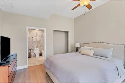 a white bedroom with a bed and a ceiling fan at Beautiful Downtown Condo 1 Bed 1 Bath in Orlando