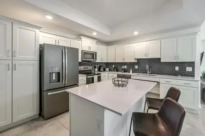 a kitchen with white cabinets and a white counter top at Apartamento 3BR/2BA – A 10 Min dos Parques Disney! in Kissimmee