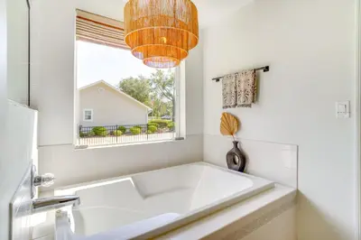 a large white tub in a white bathroom with a window at Near Parks and Lakes Sorrento Home with Pool and Yard! in Sorrento