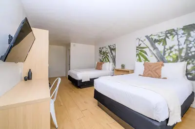a bedroom with two beds and a flat screen tv at Modern- 2 Queen bed suite with pool near Disney World in Kissimmee