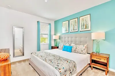 a bedroom with a bed and a blue wall at Family Home with Cinema Pool and BBQ Near Disney in Kissimmee