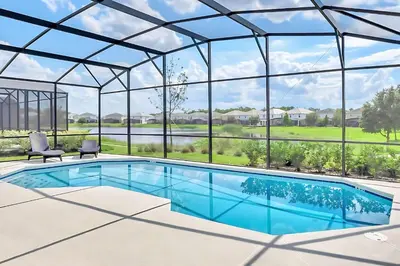 an image of a swimming pool in a glass house at Family Home with Cinema Pool and BBQ Near Disney in Kissimmee