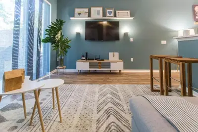 a living room with a tv on the wall at Magic Starts Here! Minutes to Disney Land in Orlando