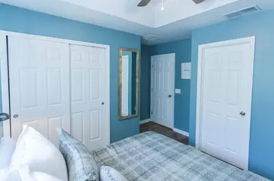 a blue bedroom with a bed and two white doors at Magic Starts Here! Minutes to Disney Land in Orlando