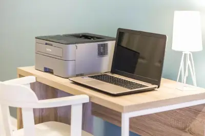 a laptop computer sitting on a desk next to a printer at Magic Starts Here! Minutes to Disney Land in Orlando
