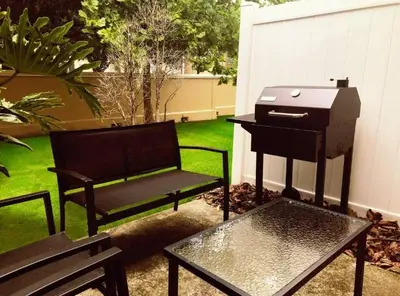 a patio with a grill and a chair and a table at Magic Starts Here! Minutes to Disney Land in Orlando