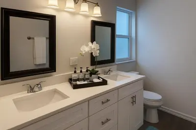 a bathroom with two sinks and a toilet and a mirror at Disney-Area 4BR | Pool + Patio in Kissimmee