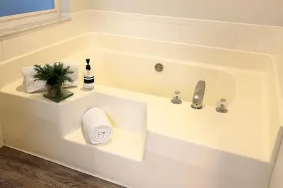 a white bath tub with a bottle of wine and a plant at Disney-Area 4BR | Pool + Patio in Kissimmee