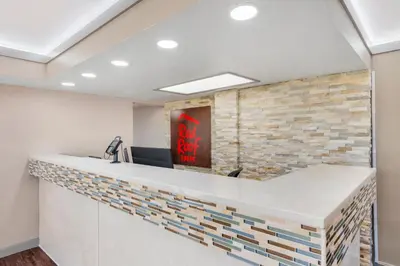 an office reception counter with a brick wall at Red Roof Inn Kissimmee, FL in Kissimmee
