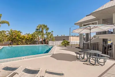a pool with chairs and a table and an umbrella at Red Roof Inn Kissimmee, FL in Kissimmee