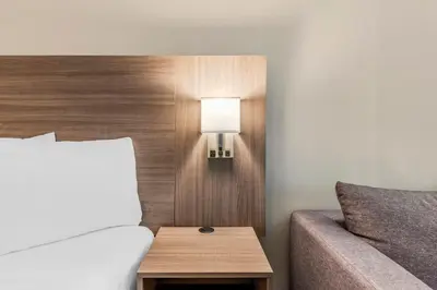 a bedroom with a bed and a lamp next to a couch at Red Roof Inn Kissimmee, FL in Kissimmee