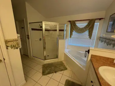 a bathroom with a shower and a sink at Sunset Villa – Your Gateway to a Magical Florida Vacation! in Kissimmee