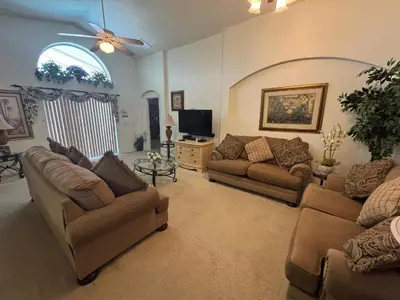 a living room with two couches and a tv at Sunset Villa – Your Gateway to a Magical Florida Vacation! in Kissimmee