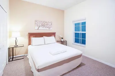 a white bedroom with a large bed and a window at Flash 20 Off Amazing Pvt Pool Townhome in Kissimmee