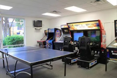 a room with a ping pong table and arcade games at Flash 20 Off Amazing Pvt Pool Townhome in Kissimmee