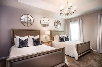 a bedroom with two beds and a chandelier at Flash 20 Off Gorgeous Vacation Home near Everywhere in Kissimmee