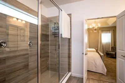 a bathroom with a glass shower and a bed at Flash 20 Off Gorgeous Vacation Home near Everywhere in Kissimmee