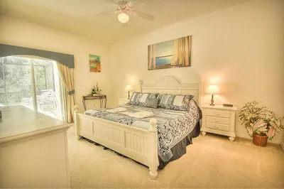 a bedroom with a large white bed and a window at Charming 4-Bedroom Villa with Pool & Spa, Only 15 Minutes from Disney! in Kissimmee