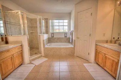 a large bathroom with a tub and a shower at Charming 4-Bedroom Villa with Pool & Spa, Only 15 Minutes from Disney! in Kissimmee