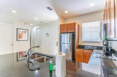 a kitchen with a sink and a stainless steel refrigerator at Flash 20 Off Private Spa Townhome at Regal Oaks Resort in Orlando