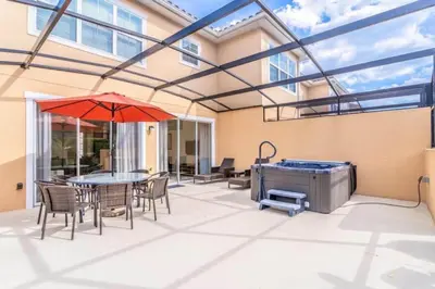 a patio with a table and chairs and a hot tub at Flash 20 Off Private Spa Townhome at Regal Oaks Resort in Orlando