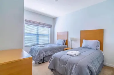 a bedroom with two beds and a desk and a window at Flash 20 Off Private Spa Townhome at Regal Oaks Resort in Orlando