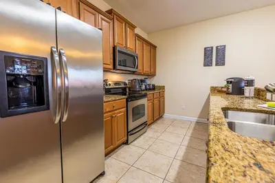 a kitchen with stainless steel appliances and wooden cabinets at Flash 20 Off Spetacular TownHome With Private Pool close to Disney 8919PP in Kissimmee